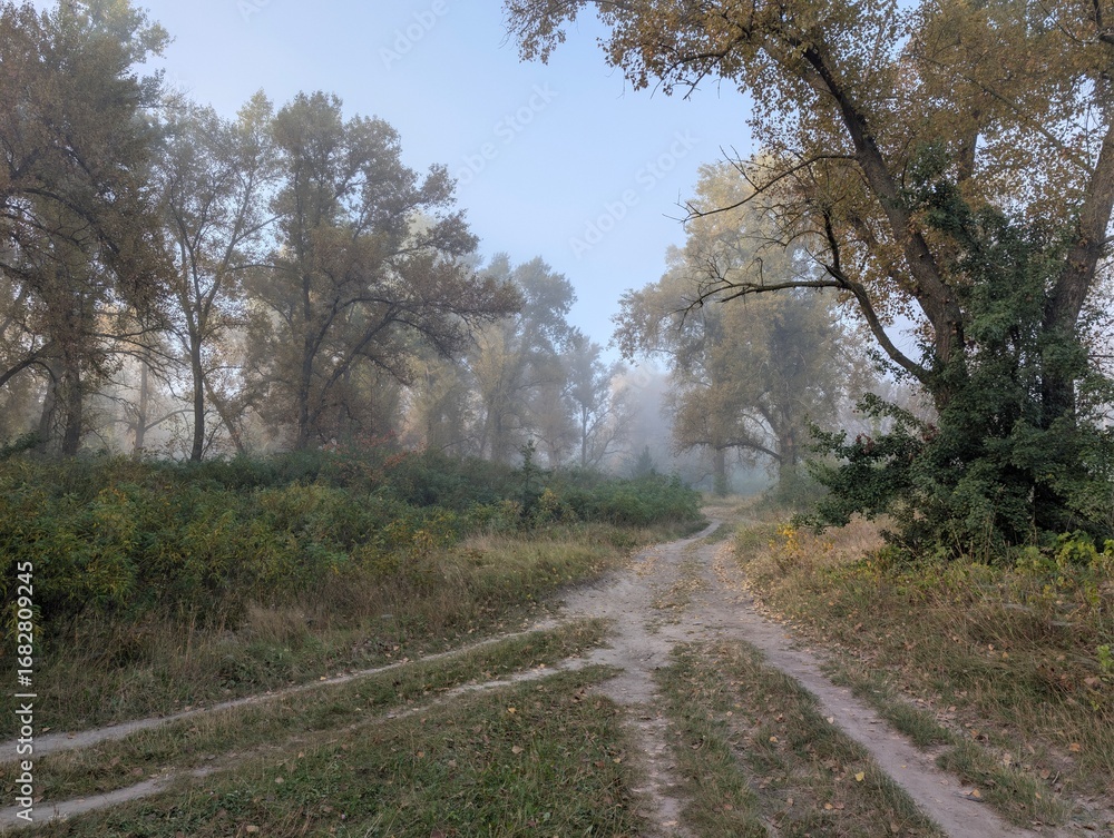 Fototapeta premium Early autumn morning with fog on the field and on the river