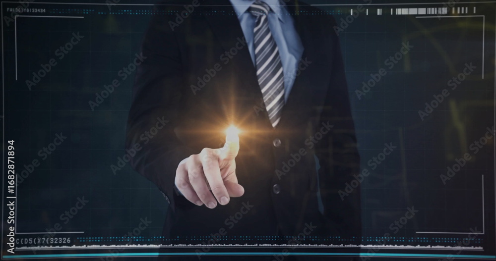 Naklejka premium Pointing executive wearing dark suit, tie touching glowing amber dot on interface wall in studio
