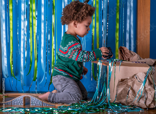 Foto Toddler plays with a train set at a Christmas party