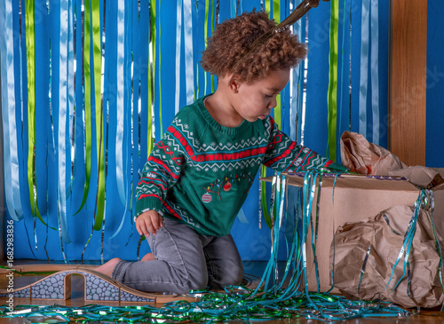 Foto Toddler plays with a train set at a Christmas party
