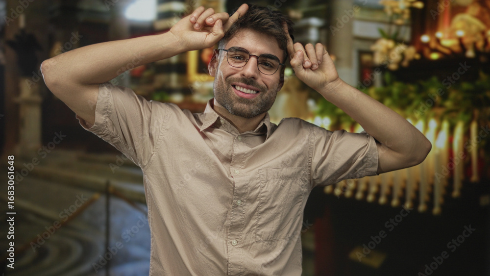 Φωτογραφία Young hispanic man showing rock horns with hands in church building; playful energy youthful spirit