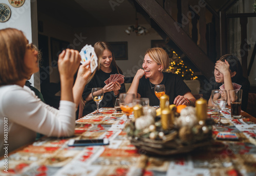Εκτύπωση καμβά Cheerfully warm home togetherness cozy scene of family playing cards together in home kitchen