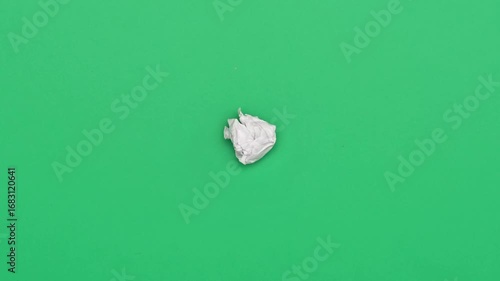 Stop motion animation of crumpled pape on a green background