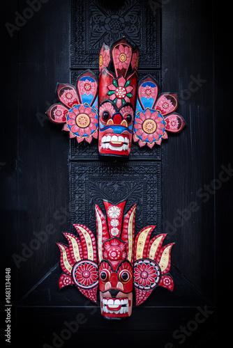 Vibrant traditional Sri Lankan wooden masks displayed on a wooden door, featuring intricate hand-painted details and bold colors.