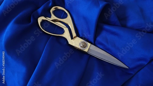 tailor scissors on blue satin fabric