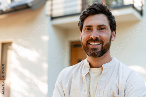 Fotografía Portrait of smiling homeowner standing in front of his house