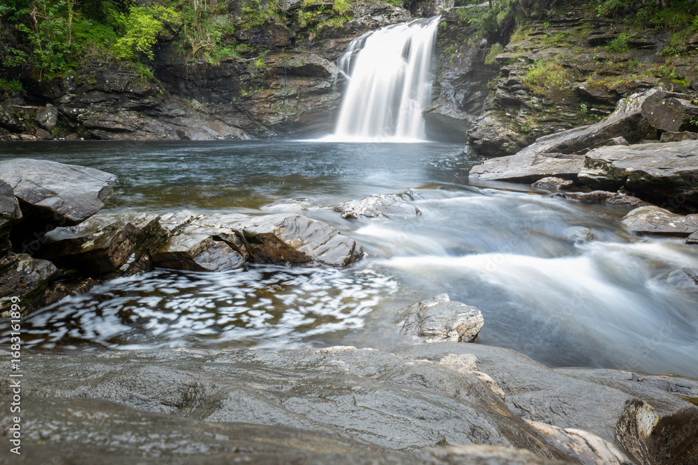 Fototapeta premium Falls of Falloch waterfall in the Loch Lomond & The Trossachs National Park. A long exposure shot of this popular beauty spot in a peaceful glen.