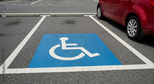 Handicapped parking spot with blue wheelchair symbol and parked car