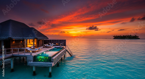 Stunning tropical sunset over a luxurious overwater bungalow in the Maldives