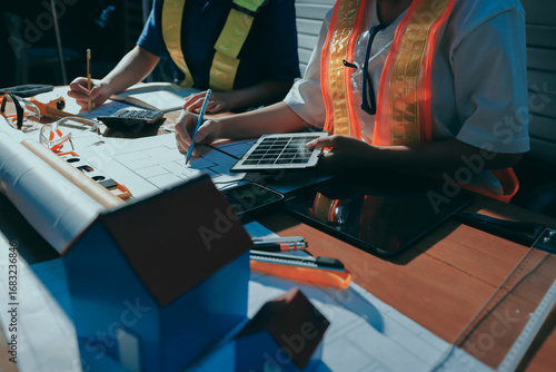 Closeup of team of industrial engineers meeting analyze machinery blueprints consult project on table in manufacturing factory. Working in manufacturing plant or production plant.