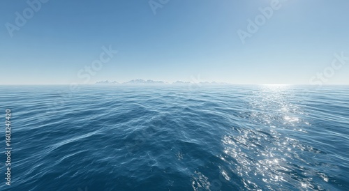 Wide shot of a calm ocean stretching to distant mountains