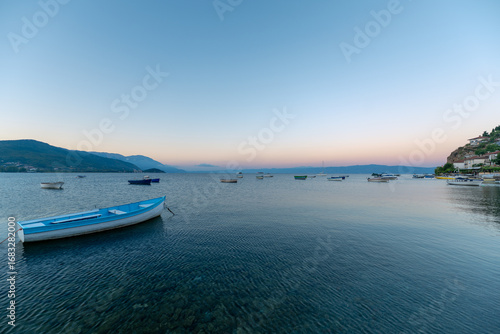 Blue boat on the lake waters and sunrise