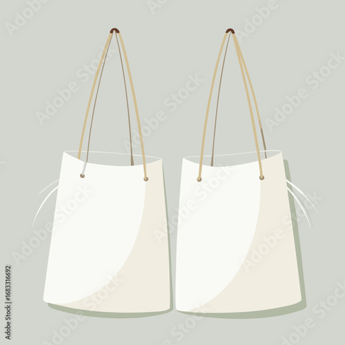 Two blank white tote bags hanging with light brown handles