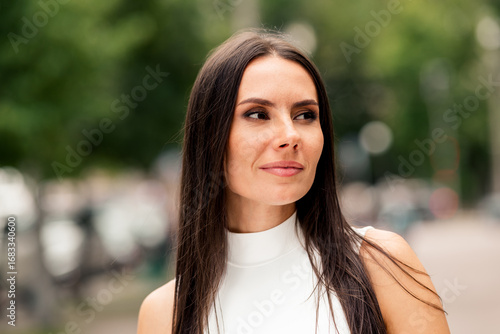 фотографія Stylish young brunette woman enjoying a sunny day outdoors in an urban setting,