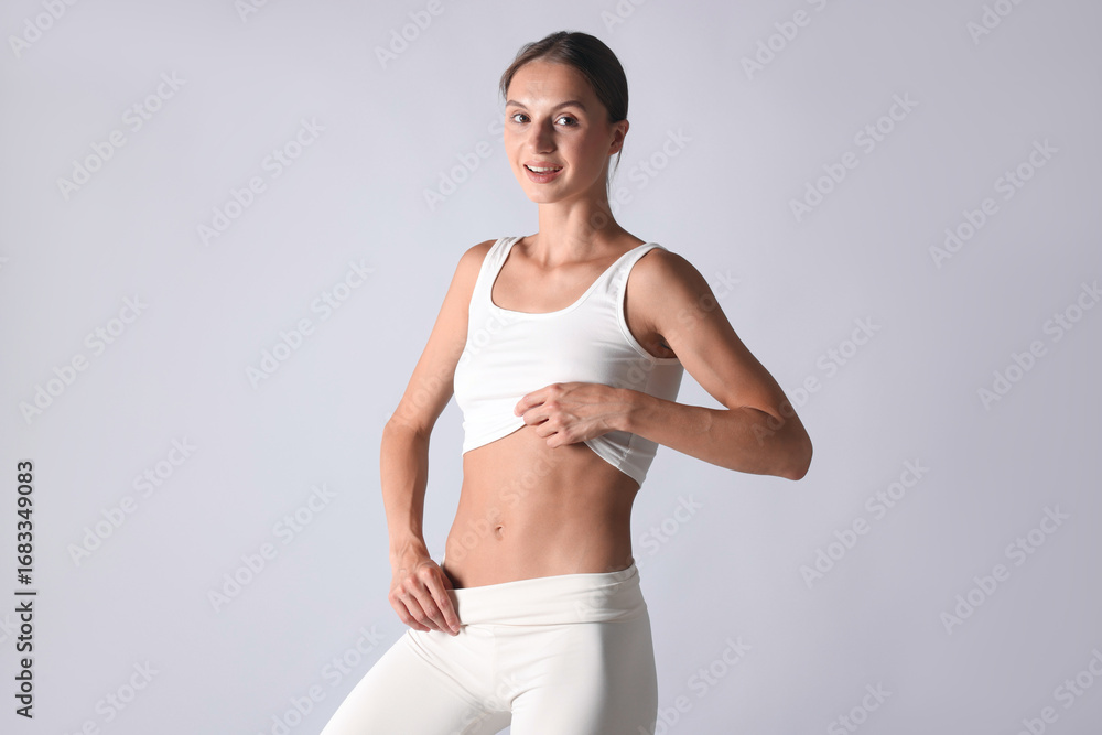 Fototapeta premium Woman with flat belly on light grey background