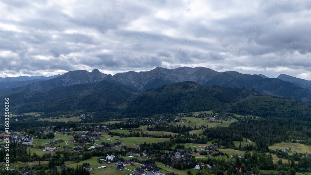 Fototapeta premium Mountain peaks near Zakopane, Poland, in summer. Lush green landscape with drifting clouds over alpine scenery. Ideal for nature, travel and outdoor visuals