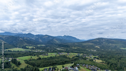 Fototapeta Naklejka Na Ścianę i Meble -  Mountain peaks near Zakopane, Poland, in summer. Lush green landscape with drifting clouds over alpine scenery. Ideal for nature, travel and outdoor visuals