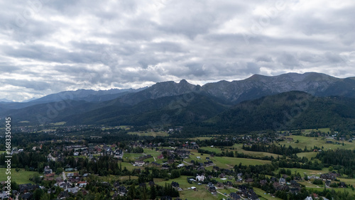Fototapeta Naklejka Na Ścianę i Meble -  Mountain peaks near Zakopane, Poland, in summer. Lush green landscape with drifting clouds over alpine scenery. Ideal for nature, travel and outdoor visuals