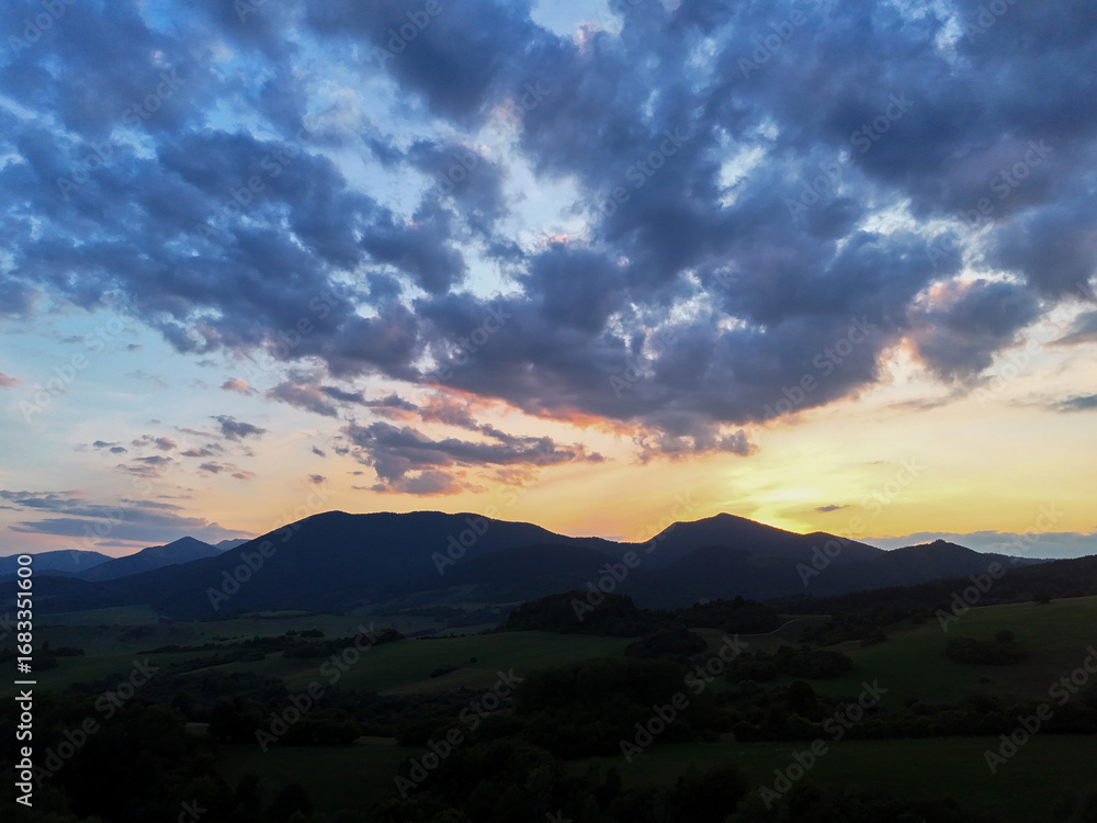 Fototapeta premium Sunset view of mountain peaks near Dolny Kubin in the Orava region of Slovakia. Warm light over scenic landscape in the Zilina region. Perfect for nature, travel and cinematic visuals.