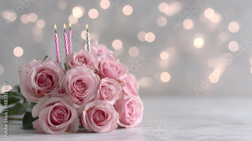 Beautiful pink roses with candles for birthday celebration on marble table