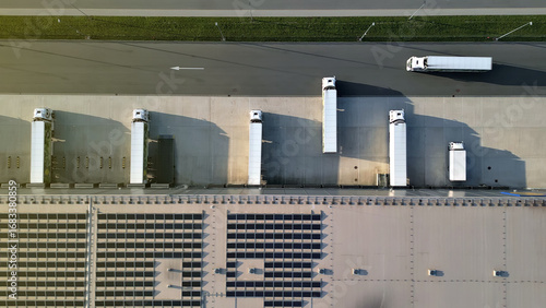 Photos Aerial view of a distribution warehouse with cargo trucks lined up for loading/unloading, showcasing efficient freight logistics and organized supply chain management
