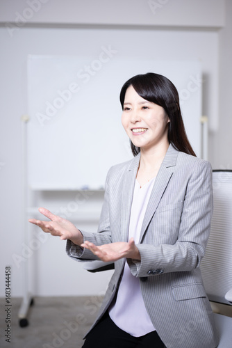 ホワイトボードの前でインタビューに応える女性8