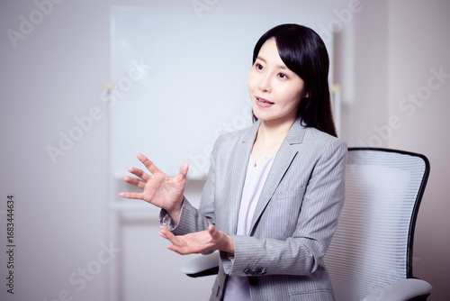 ホワイトボードの前でインタビューに応える女性10