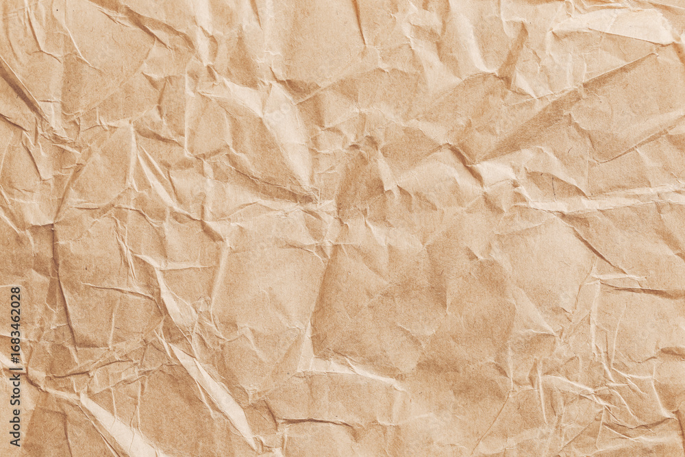 Obraz premium Crumpled brown paper texture background. Recycled eco material. Wrinkled surface pattern. Natural kraft packaging design. Decorative rough sheet detail. Craft wrapping element concept.