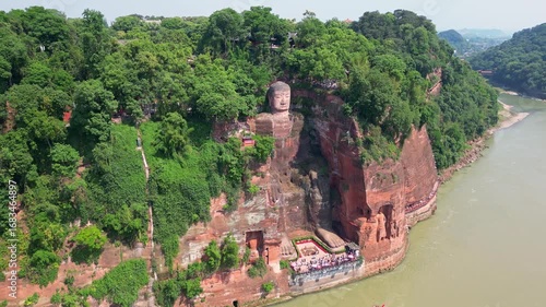 Leshan, China: Aerial orbit drone footage of the famous Leshan giant Buddha stone statue  at the confluence of the Min River and Dadu River in Sichuan in China.