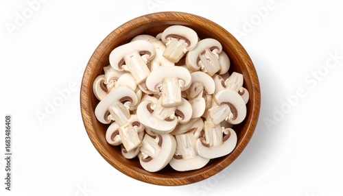 Top view of fresh sliced champignon mushrooms in a wooden bowl, isolated on a white background.