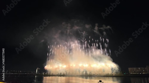 夜の大分市街と大分川の上空に広がる打ち上げ花火