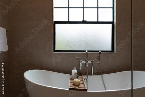 Fotografía Relaxing scene of soaking tub with wavy pattern tiled bathroom wall and window light