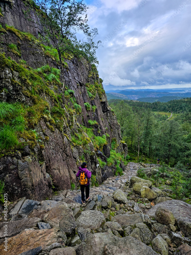 Obraz premium Exploring the rugged terrain of Preikestolen Cliff in Norway during a cloudy day