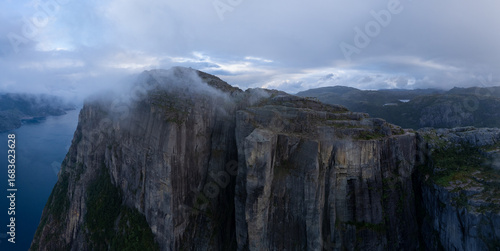 Bild auf Leinwand Majestic cliffs rising above the tranquil waters of Norways enchanting fjords