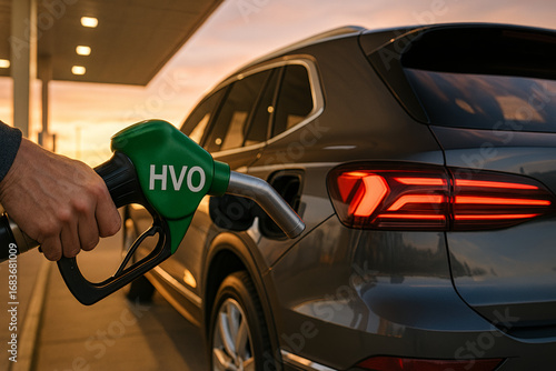 Close-up ultra sharp HVO nozzle fueling luxury SUV at modern fueling station, sunset lighting, realistic eco mobility stock photo