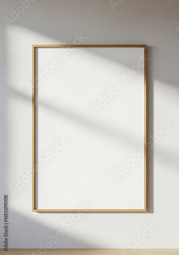 Blank vertical wooden picture frame mockup hanging on a wall with soft window shadows.
