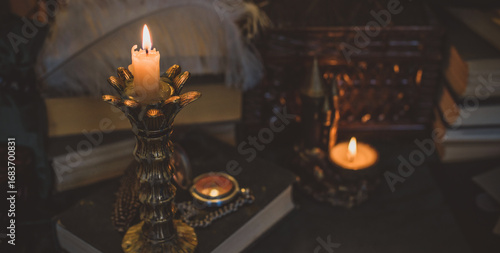 Obraz na płótnie Book and candle on a vintage table, dark academia aesthetic
