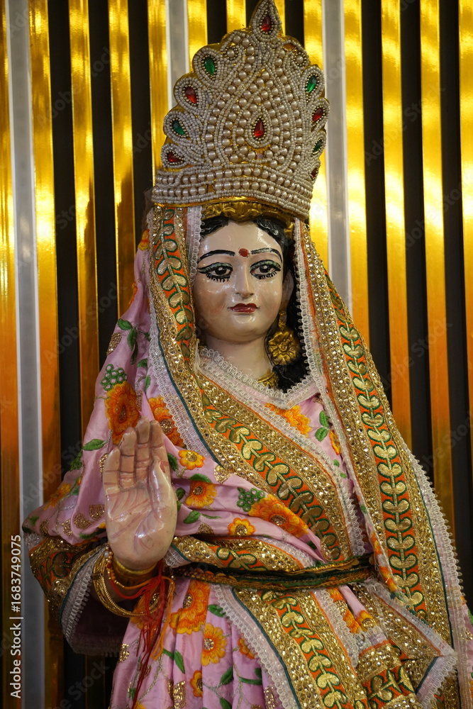 Obraz premium Traditional Indian Goddess Sita Mata Statue with Elaborate Dress and Golden Decorative Setting