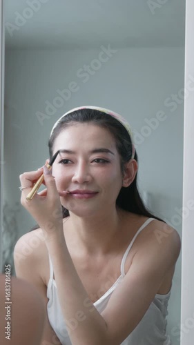 woman applies makeup and writes her schedule before heading out to work.