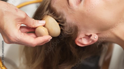 A young woman is given a relaxing massage during a spa treatment. The experienced hands of the masseur gently press on the skin, ensuring complete relaxation and restoration of strength.