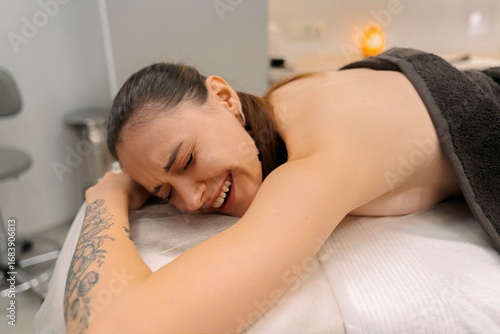 Papier peint Woman Reacting During Deep Tissue Massage Session