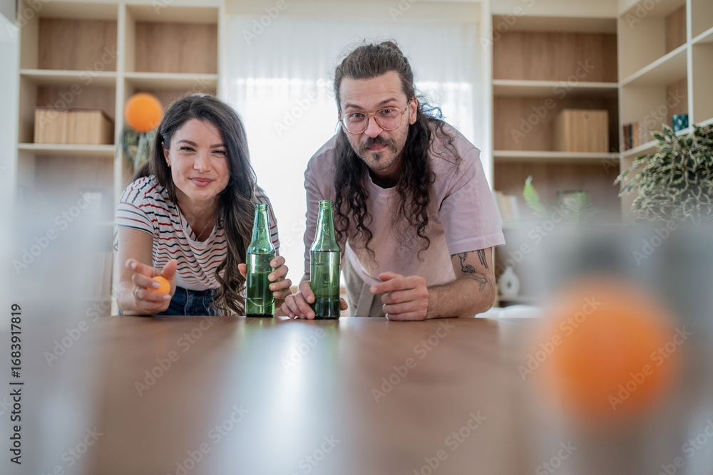 Fototapeta premium Couple playing beer pong at home, throwing ping pong balls