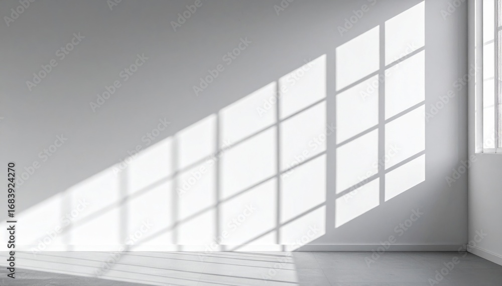 Fototapeta premium Bright Sunlight Casting Geometric Shadows on a White Wall in a Minimalist Room Interior