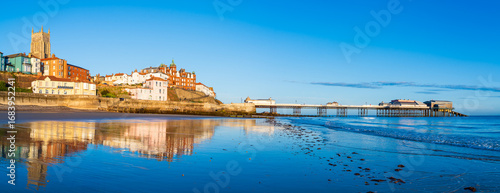 A panoramic view of Cromer town with the Victorian pier and Parish Church with sunrise light