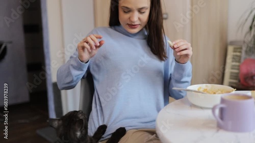 a young woman having breakfast at home at the table