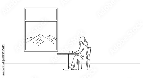 Woman sitting at a table by the window enjoying the mountain view