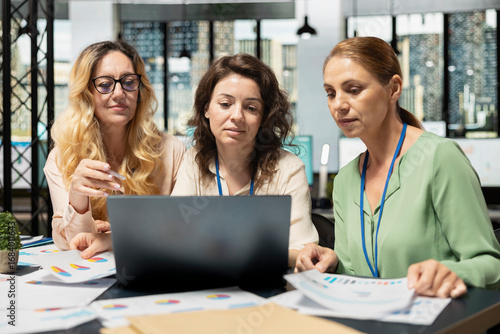 Photos Diverse team members exchanging data reports in a briefing session, sharing vision ideas to build a strong company with objectives for success