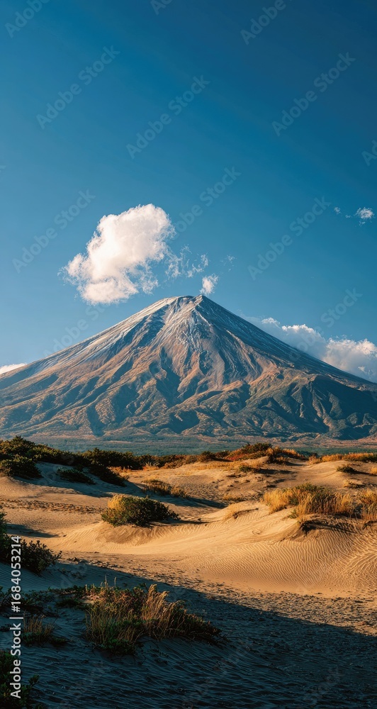 Fototapeta premium Volcanic peak above desert dunes