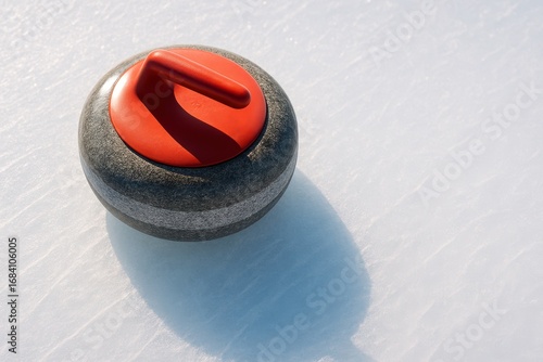 A single curling stone with a bright  handle sits poised on the smooth, reflective ice of a curling sheet, its shadow stretching across the surface.