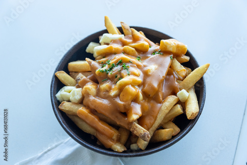 Classic Canadian poutine with French fries, cheese curds, and rich gravy served in a bowl.